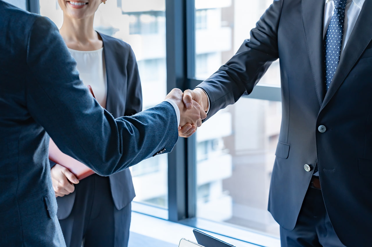 スーツを着た人たちが握手をする様子