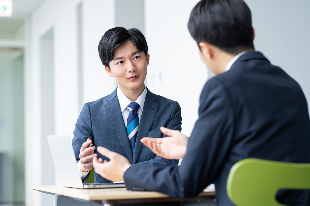 スーツを着た男性が商談する様子